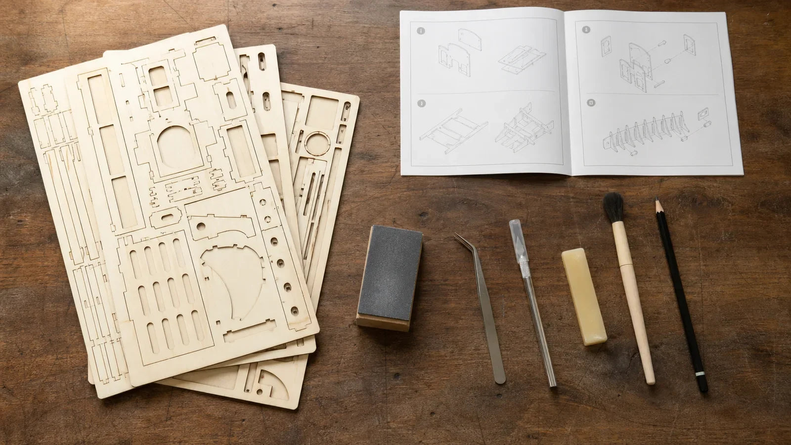 Laser-cut wooden sheets and model-making tools arranged on a workbench